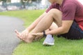 Ankle sprained. Young man suffering from an ankle injury while running at park. Healthcare and sport concept