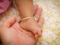 Anklet of newborns in mom's hand Royalty Free Stock Photo