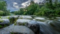 Ann arbor cascades park with moving water flowing along rocks under a blue sky