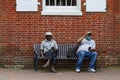 Two African American male sitting on a bench