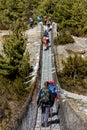 Annapurna, Nepal - November 8, 2015: Tourists crossing suspension bridge on Annapurna Trek, Himalayas, Nepal