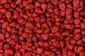 Annatto seeds, achiote seeds, bixa orellana background. Natural dye for cooking and food. Close-up.