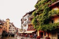 Annecy city water channel, red flowers, old buildings, bridge, green balconies