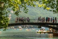 Tourists enjoying the lake from the Pont des Amours bridge in Annecy, France