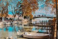 ANNECY, FRANCE - NOVEMBER 18, 2018: beautiful view at autumn Annecy lake and channel with boat, bridge and mountain at background.