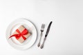 Anniversary, birthsday festive romantic table setting on white background. Kraft gift box with red ribbon in ceramic