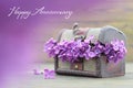 Anniversary card with lilac flowers in wooden chest Royalty Free Stock Photo