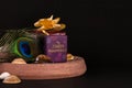 Anniversary gift concept. Beautiful peacock feather with decorated gift box and spreaded seashells on black background Royalty Free Stock Photo