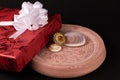 Anniversary gift concept. Cocktail ring with decorated red giftbox and seashell on sand stone with dark background Royalty Free Stock Photo