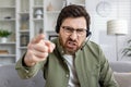 Frustrated man with headset pointing finger in a work from home setting