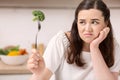 Annoyed bleak woman eating broccoli Royalty Free Stock Photo