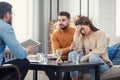 Annoyed caucasian couple of man and woman having conversation with psychologist on therapy session in light room.