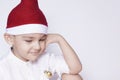 A little kid making a funny annoyed face. Annoyed Christmas Boy in Santa Hat. A really serious and handsome kid Royalty Free Stock Photo