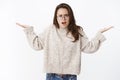 Annoyed and confused girl having argument standing questioned and waiting explanations making shoulder shrug with Royalty Free Stock Photo