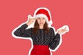 Annoyed and displeased woman in dress shrugging and holding fingers on temple. emotional girl in santa claus christmas hat Royalty Free Stock Photo