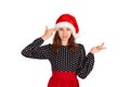 Annoyed and displeased woman in dress shrugging and holding fingers on temple. emotional girl in santa claus christmas hat isolate Royalty Free Stock Photo