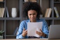 Annoyed frustrated African student girl receiving paper letter