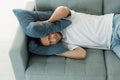 Annoyed man cover ears with pillows to avoid noise from neighbor while napping on couch try to sleep Royalty Free Stock Photo