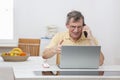 Annoyed mature man having problems while working from home with computer or internet