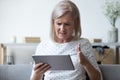 Annoyed mature woman having problem with computer tablet