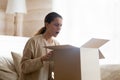 Annoyed millennial woman customer of internet shop receiving broken goods