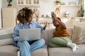 Annoyed mother working on laptop asking child not to disturb her