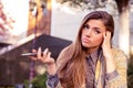 Annoyed sad woman with mobile phone standing outside in the street with an urban background Royalty Free Stock Photo