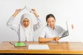 annoyed school girls with slamming pose of laptop and books