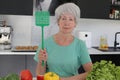 Annoyed senior woman ready to catch an insect inside of her house