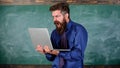 Annoyed by slow internet. Slowly internet annoying him. Teacher bearded man modern laptop chalkboard background. Hipster