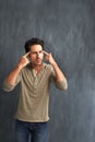 Annoyed, thinking and portrait of man by a wall with doubt, moody and angry facial expression. Upset, question and young