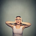 Annoyed, unhappy, stressed woman covering her ears, looking up Royalty Free Stock Photo