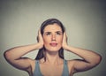 Annoyed, unhappy, stressed woman covering her ears, looking up Royalty Free Stock Photo