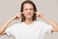 Annoyed unhappy woman plug ears with fingers, avoid loud noise