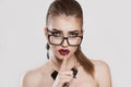 Annoyed upset woman with glasses showing silence hand gesture