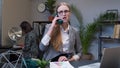 Annoyed young businesswoman talking on retro telephone call irritated voice dissatisfied with work