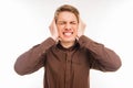 Annoyed young man plugging ears with hands Royalty Free Stock Photo