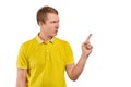 Annoyed young man in yellow T-shirt threatening be more attentive, white background, finger gesture