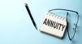 ANNUITY text is written on a notepad on the blue background Royalty Free Stock Photo