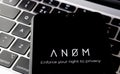 ANOM app logo seen on the smartphone and laptop on blurred background. Encrypted messaging app used in global crime networks.