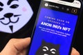 Anon Inu NFT non fungible token. Man hold mobile phone with anon inu web site, close-up