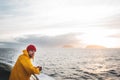 Anone man traveler floating on ship looking at sunset sea after storm and foggy mountains on skyline Royalty Free Stock Photo