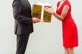 Anonym businessman give a present woman in red dress.