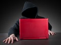 Anonym with hood and red laptop Royalty Free Stock Photo