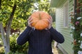 Anonym man holding a pumpkin in hands like a head. Royalty Free Stock Photo