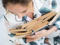 Anonymous adult woman holding open a lot of books in hands with love to reading. Close up of female hands and book Royalty Free Stock Photo