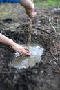 Anonymous child hands having fun playing with mud and water