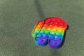 Anonymous child hold in his hands sensory toy pop it and shows it in front of himself.Rainbow color.Antistress toy for