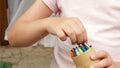 Anonymous child, school age girl holding a box of crayons choosing one crayon detail hands closeup, creativity arts and crafts art