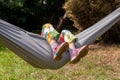 Anonymous child, school age girl laying on a hammock feet legs up, face obscured, outdoors scene, summer fun and leisure, resting